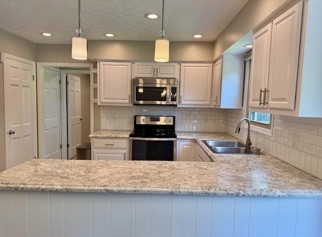 1724 Ramblewood Ave, Columbus, OH 43235 - kitchen with stainless steel appliances, backsplash, white cabinetry, hanging light fixtures, and recessed lighting