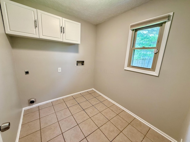 1724 Ramblewood Ave, Columbus, OH 43235 - laundry area featuring electric dryer hookup, hookup for a washing machine, cabinet space, a textured ceiling, and light tile patterned floors
