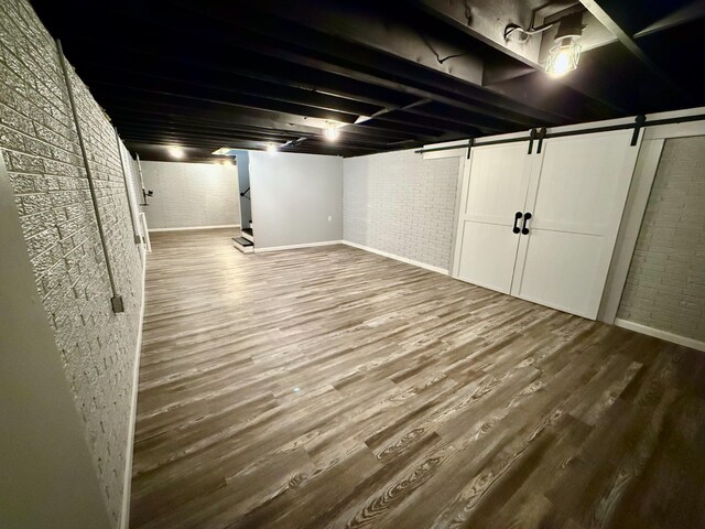 1724 Ramblewood Ave, Columbus, OH 43235 - finished below grade area featuring wood finished floors, brick wall, and a barn door