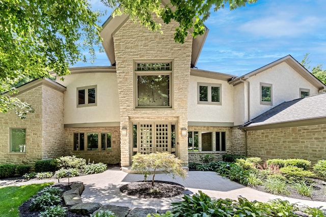 1967 Woodlands Pl, Powell, OH 43065 - back of house featuring stucco siding, stone siding, and a patio area
