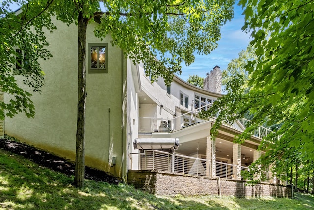 1967 Woodlands Pl, Powell, OH 43065 - view of side of property with stucco siding, a balcony, and a chimney