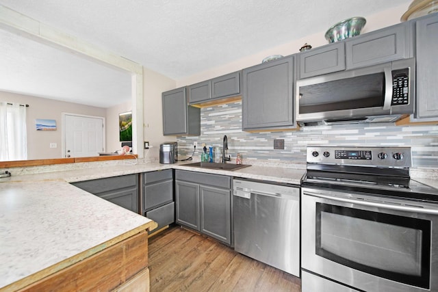 136 Ridgeview Ct, Johnstown, OH 43031 - kitchen featuring stainless steel appliances, gray cabinets, backsplash, and light wood-style flooring