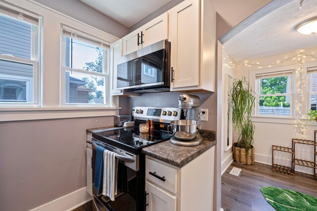 297 Central Ave, Newark, OH 43055 - kitchen featuring appliances with stainless steel finishes, dark wood-style floors, dark countertops, and white cabinets