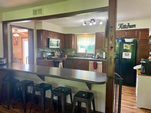 10363 Bremen Rd, Logan, OH 43138 - kitchen featuring stainless steel appliances, a kitchen bar, a ceiling fan, and tasteful backsplash