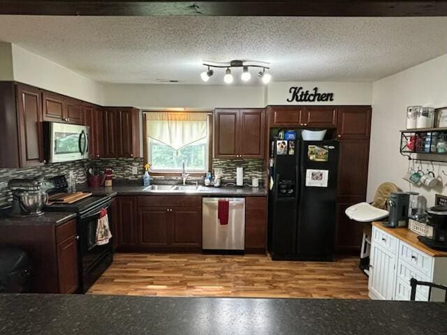 10363 Bremen Rd, Logan, OH 43138 - kitchen with black appliances, dark countertops, decorative backsplash, and light wood-type flooring