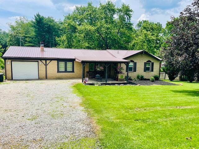 10363 Bremen Rd, Logan, OH 43138 - ranch-style house featuring a garage, driveway, a front yard, and a metal roof