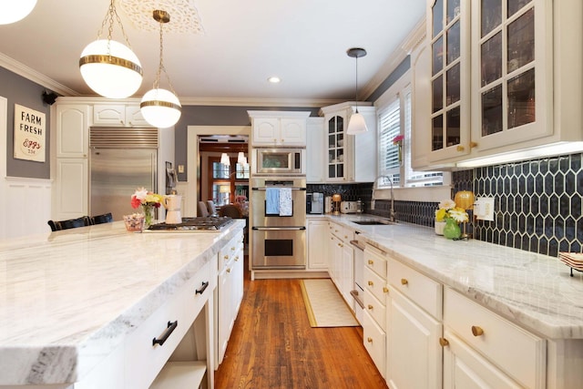 2465 E Broad St, Bexley, OH 43209 - kitchen with built in appliances, ornamental molding, decorative backsplash, light stone counters, and glass insert cabinets