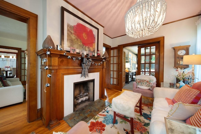 2465 E Broad St, Bexley, OH 43209 - living area with a chandelier, wood finished floors, ornamental molding, a fireplace, and french doors