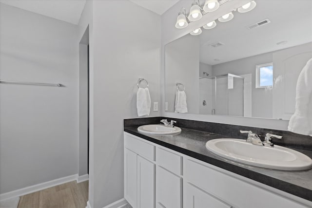 5423 Morning Glory St, South Bloomfield, OH 43103 - bathroom featuring a shower stall, double vanity, and wood finished floors