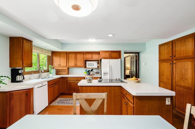 1133 Rockport Ln, Columbus, OH 43235 - kitchen featuring white appliances, a kitchen island, brown cabinetry, light countertops, and recessed lighting