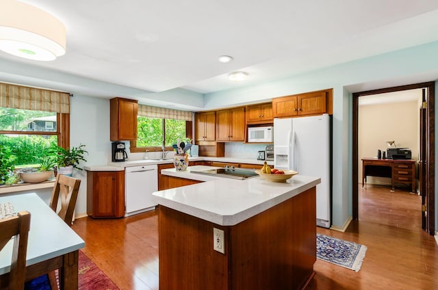 1133 Rockport Ln, Columbus, OH 43235 - kitchen featuring white appliances, wood finished floors, light countertops, brown cabinets, and recessed lighting