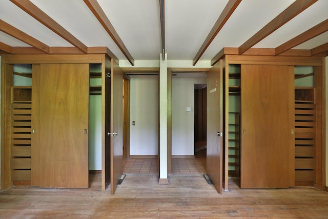 230 E S St, Worthington, OH 43085 - unfurnished bedroom featuring wood finished floors, two closets, and beam ceiling