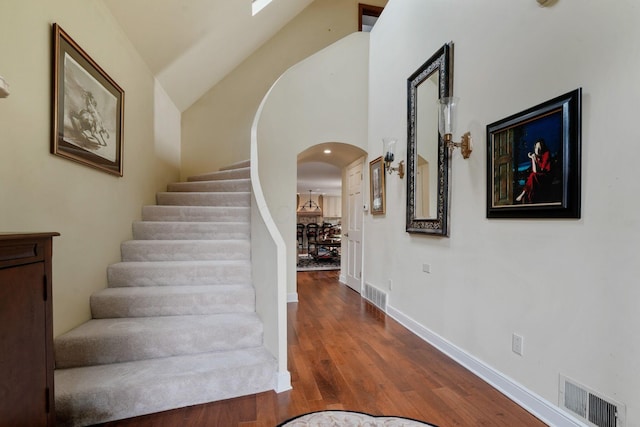 161 Jackson St, Columbus, OH 43206 - staircase featuring arched walkways, wood finished floors, and high vaulted ceiling