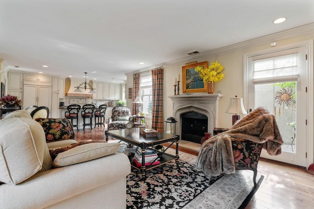 161 Jackson St, Columbus, OH 43206 - living area with a fireplace with raised hearth, light wood-style flooring, ornamental molding, and recessed lighting