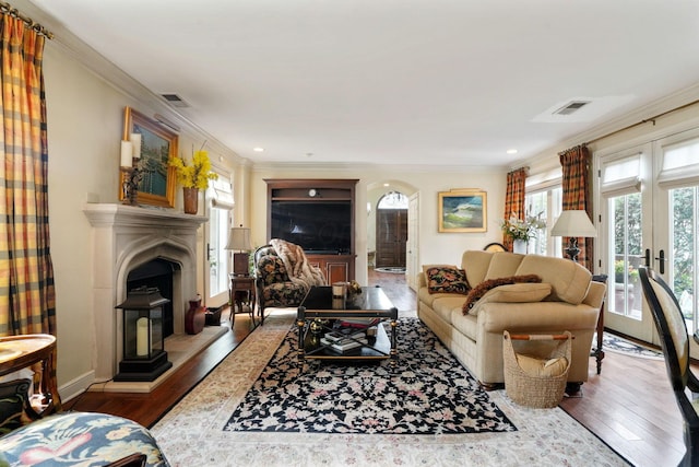 161 Jackson St, Columbus, OH 43206 - living room featuring plenty of natural light, a fireplace with raised hearth, wood finished floors, crown molding, and arched walkways