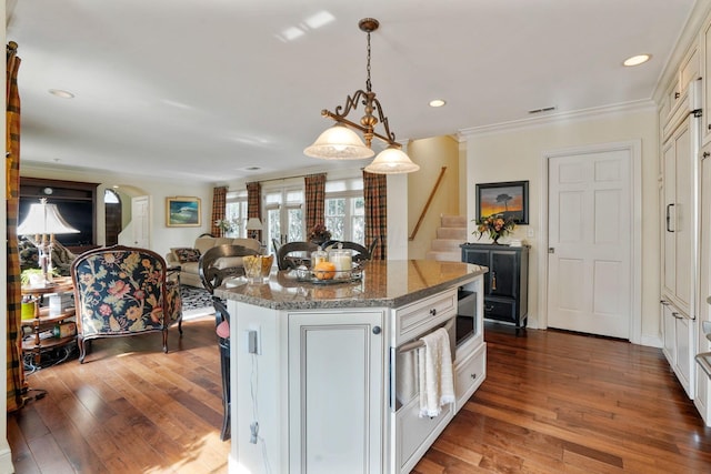 161 Jackson St, Columbus, OH 43206 - kitchen with a kitchen island, dark wood-style floors, decorative light fixtures, light stone counters, and crown molding