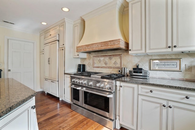 161 Jackson St, Columbus, OH 43206 - kitchen with high end appliances, custom range hood, dark wood-style floors, dark stone countertops, and recessed lighting