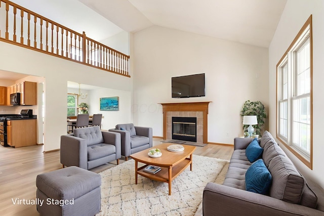 113 Olentangy Meadows Dr, Lewis Center, OH 43035 - living area featuring light wood-style floors, plenty of natural light, a fireplace, a chandelier, and high vaulted ceiling