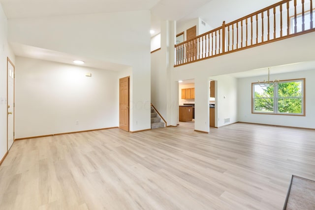 113 Olentangy Meadows Dr, Lewis Center, OH 43035 - unfurnished living room with stairs, light wood-type flooring, a chandelier, a towering ceiling, and recessed lighting