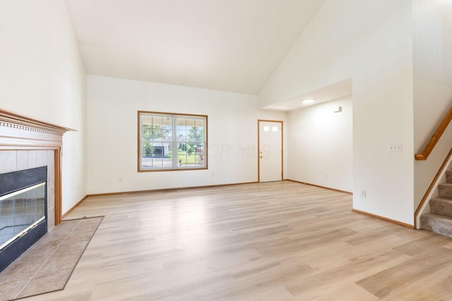 113 Olentangy Meadows Dr, Lewis Center, OH 43035 - unfurnished living room featuring stairway, light wood-type flooring, high vaulted ceiling, and a fireplace