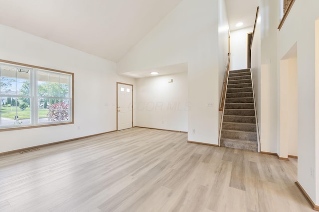 113 Olentangy Meadows Dr, Lewis Center, OH 43035 - unfurnished living room featuring light wood-type flooring, stairway, high vaulted ceiling, and recessed lighting