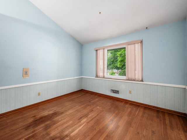 1530 Pemberton Dr, Columbus, OH 43221 - empty room with wood finished floors, a wainscoted wall, and lofted ceiling