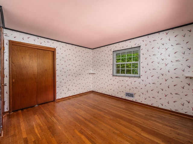 1530 Pemberton Dr, Columbus, OH 43221 - unfurnished bedroom with wood-type flooring, ornamental molding, and wallpapered walls