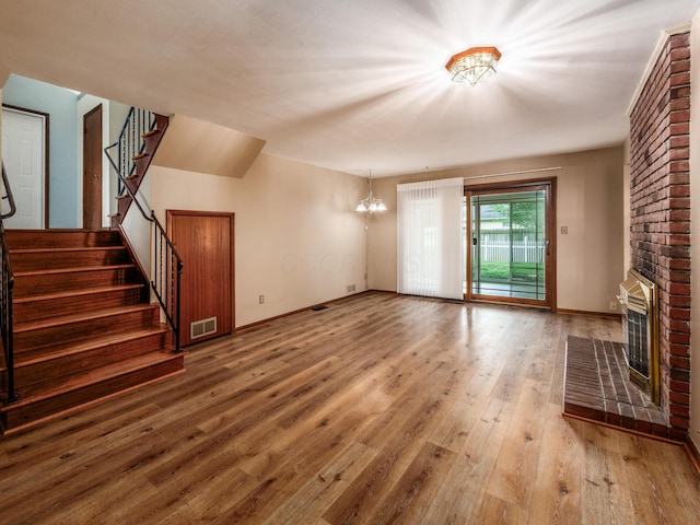 1530 Pemberton Dr, Columbus, OH 43221 - unfurnished living room with wood finished floors, a chandelier, stairway, and a fireplace