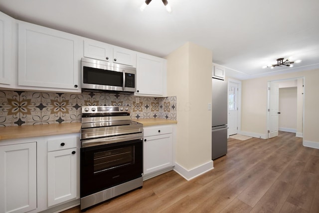 11 E Main St, Sparta, OH 43350 - kitchen featuring appliances with stainless steel finishes, light countertops, light wood-type flooring, and white cabinetry