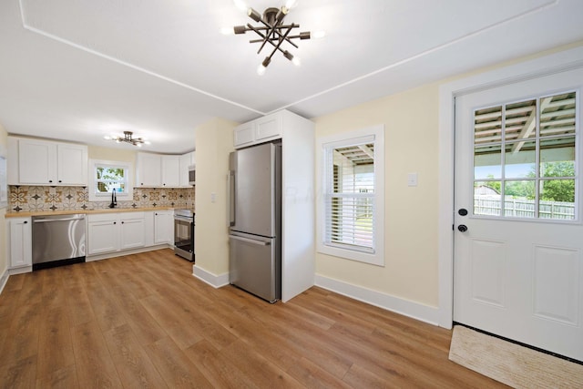 11 E Main St, Sparta, OH 43350 - kitchen with appliances with stainless steel finishes, a chandelier, and light wood-type flooring