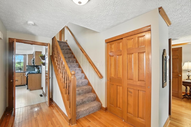 1482 Buckpoint Ln, Worthington, OH 43085 - staircase featuring a textured ceiling and wood-type flooring