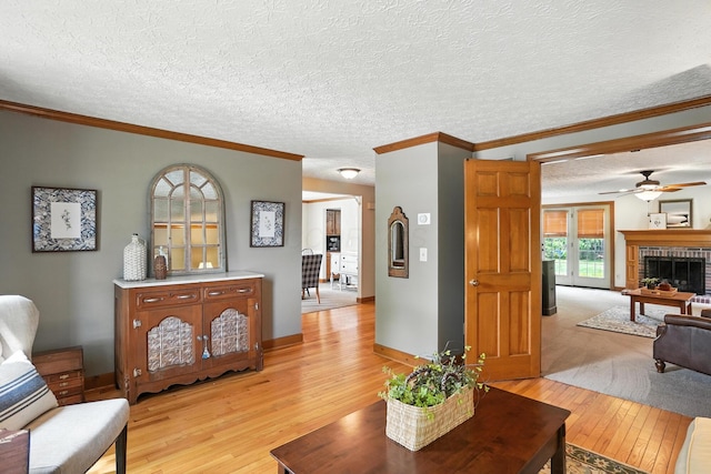 1482 Buckpoint Ln, Worthington, OH 43085 - living area with light wood-style floors, ceiling fan, ornamental molding, a fireplace, and a textured ceiling