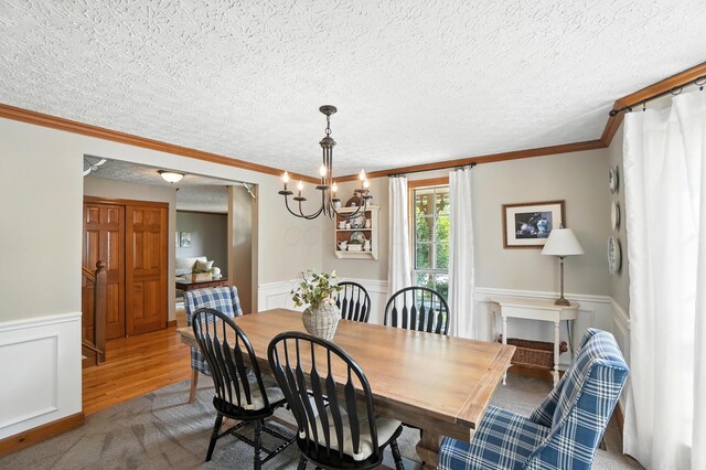 1482 Buckpoint Ln, Worthington, OH 43085 - dining room with a wainscoted wall, a chandelier, crown molding, a textured ceiling, and a decorative wall
