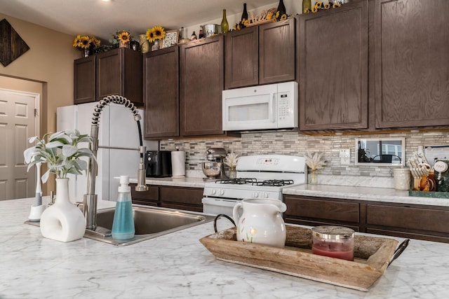 5070 River Bend Dr, South Bloomfield, OH 43103 - kitchen with white appliances, backsplash, dark brown cabinetry, and marble finish floors