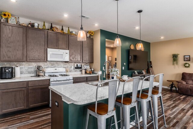 5070 River Bend Dr, South Bloomfield, OH 43103 - kitchen featuring white appliances, light countertops, dark wood-style floors, a kitchen bar, and recessed lighting