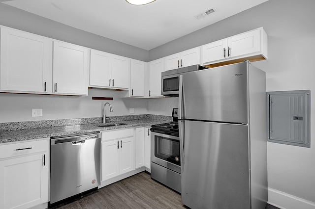 126 E 6th Ave Unit 126, Columbus, OH 43201 - kitchen featuring appliances with stainless steel finishes, electric panel, light stone counters, and white cabinets