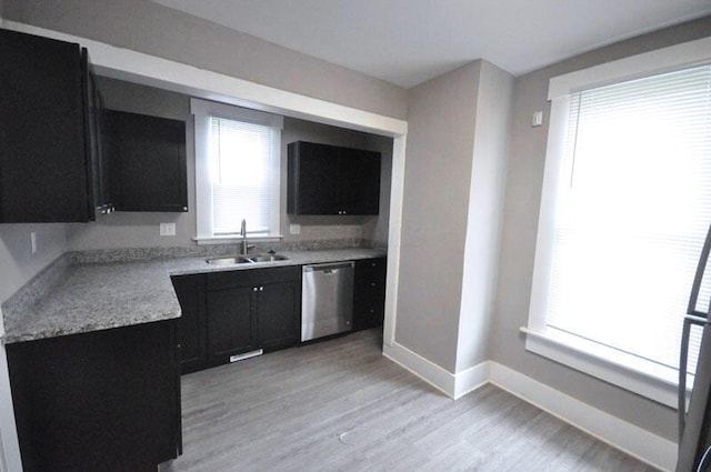 126 E 6th Ave Unit 126, Columbus, OH 43201 - kitchen featuring stainless steel dishwasher, dark cabinets, light wood-type flooring, and light countertops