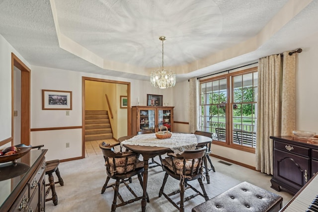 6281 Davis Dr, Newark, OH 43056 - dining space with stairs, light carpet, a textured ceiling, a chandelier, and a raised ceiling