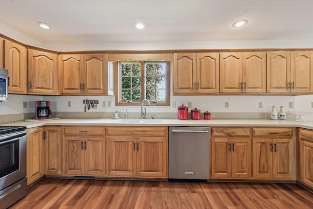 6281 Davis Dr, Newark, OH 43056 - kitchen featuring stainless steel appliances, light countertops, dark wood-type flooring, brown cabinets, and recessed lighting