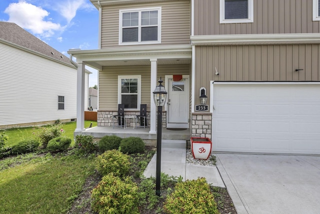 235 Old Bay Dr, Pataskala, OH 43062 - property entrance featuring a porch, a garage, stone siding, board and batten siding, and driveway