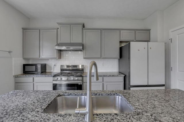 235 Old Bay Dr, Pataskala, OH 43062 - kitchen featuring range hood, black microwave, freestanding refrigerator, stainless steel range with gas cooktop, and gray cabinets