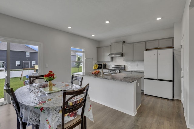 235 Old Bay Dr, Pataskala, OH 43062 - kitchen with freestanding refrigerator, stainless steel range oven, gray cabinets, under cabinet range hood, and a center island with sink