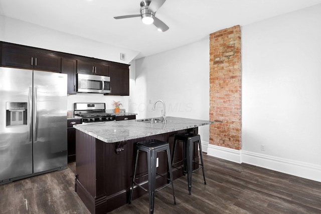611 E 11th Ave, Columbus, OH 43211 - kitchen featuring appliances with stainless steel finishes, light stone counters, a ceiling fan, and dark wood-style flooring