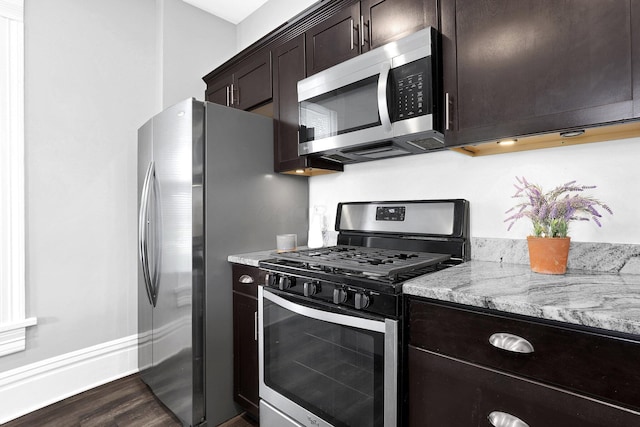611 E 11th Ave, Columbus, OH 43211 - kitchen featuring appliances with stainless steel finishes, dark wood finished floors, dark brown cabinetry, and light stone countertops