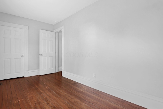 611 E 11th Ave, Columbus, OH 43211 - unfurnished bedroom featuring dark wood finished floors and baseboards