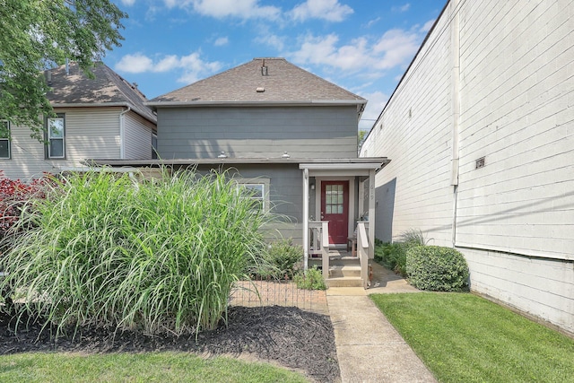 617 E 11th Ave, Columbus, OH 43211 - shotgun-style home with a shingled roof and a front lawn