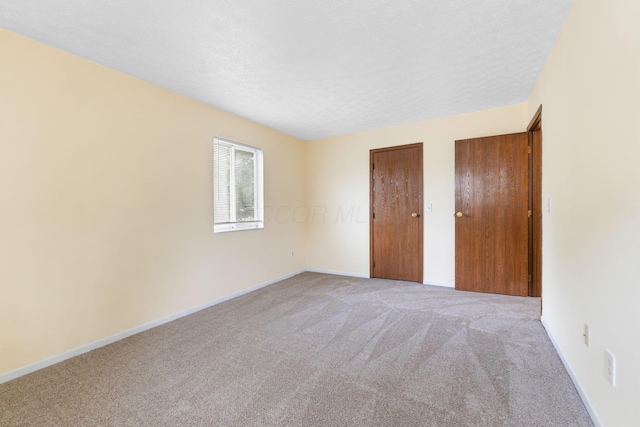 5198 Dierker Rd Unit D, Columbus, OH 43220 - unfurnished bedroom featuring light colored carpet, multiple closets, and a textured ceiling