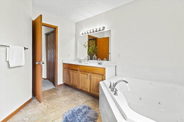 1280 Kariba Dr, Columbus, OH 43207 - bathroom with double vanity, a whirlpool tub, and a textured ceiling