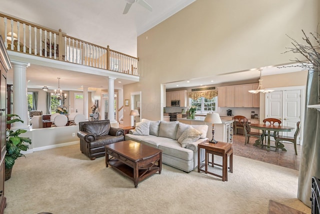 6150 Heritage Lakes Dr, Hilliard, OH 43026 - living area featuring ornate columns, light colored carpet, a towering ceiling, a chandelier, and a ceiling fan