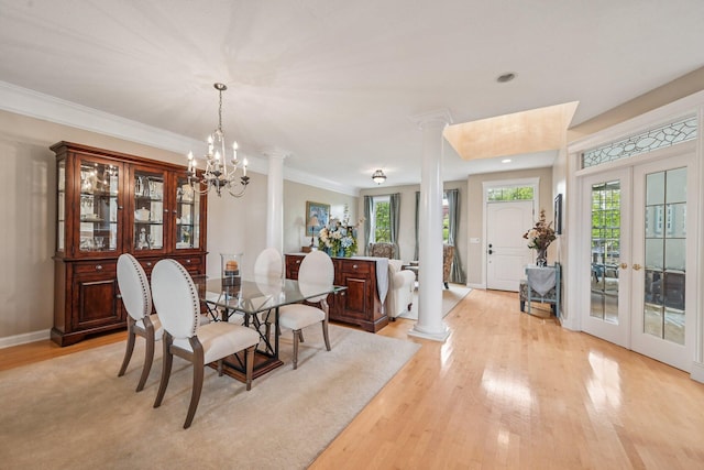 6150 Heritage Lakes Dr, Hilliard, OH 43026 - dining area featuring light wood-style floors, ornate columns, french doors, a chandelier, and crown molding